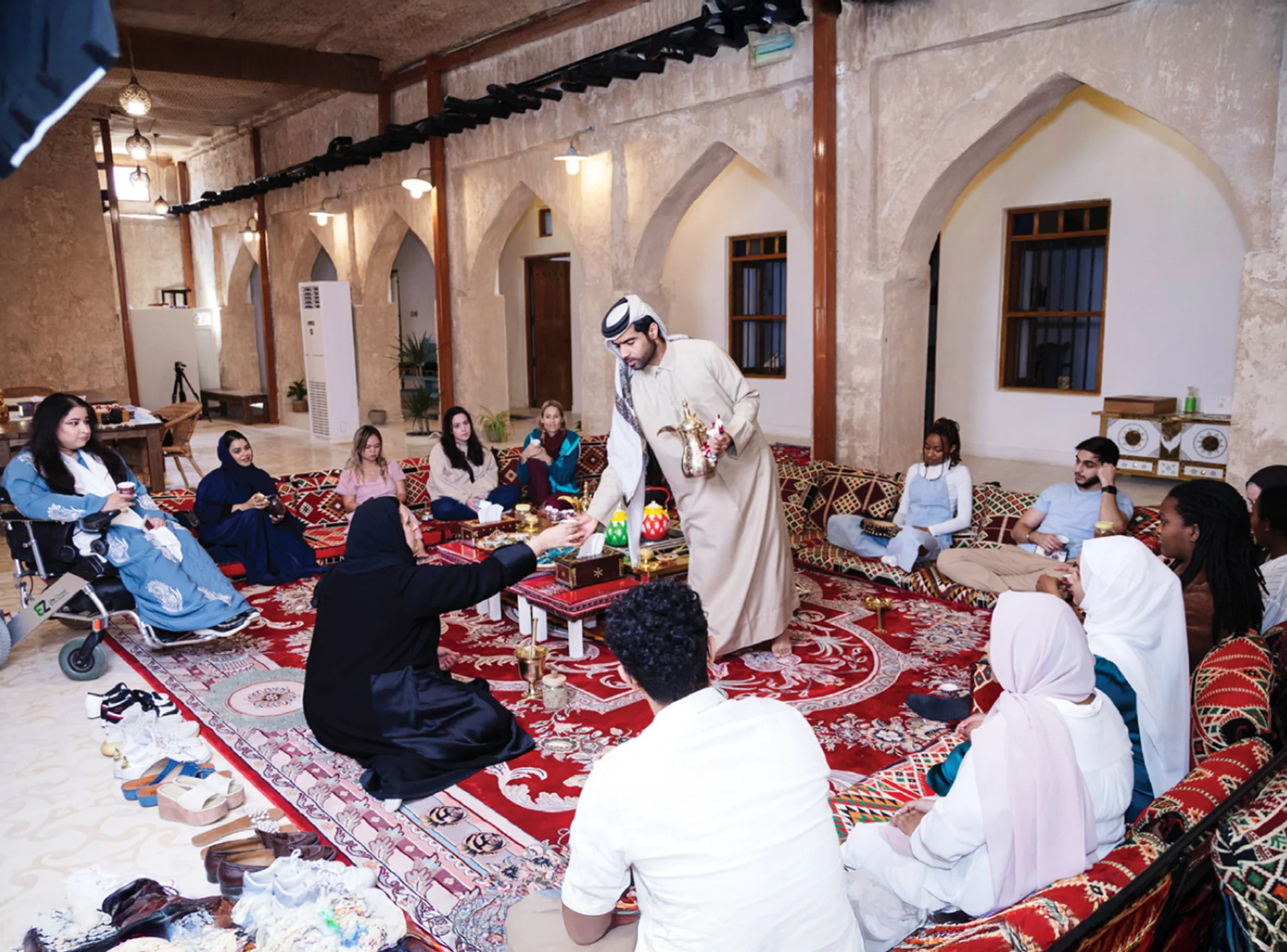 Guests enjoying a traditional Majlis experience in Qatar with Arabic coffee, tea, and cultural conversations.