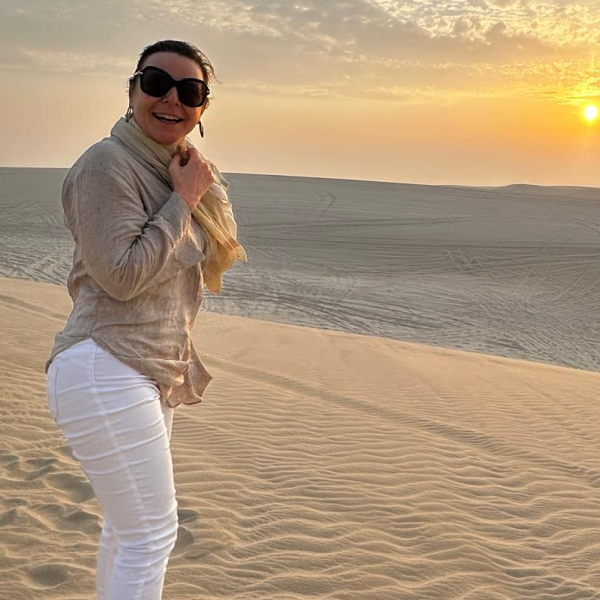 Happy travellers enjoying desert safari on golden sand dunes